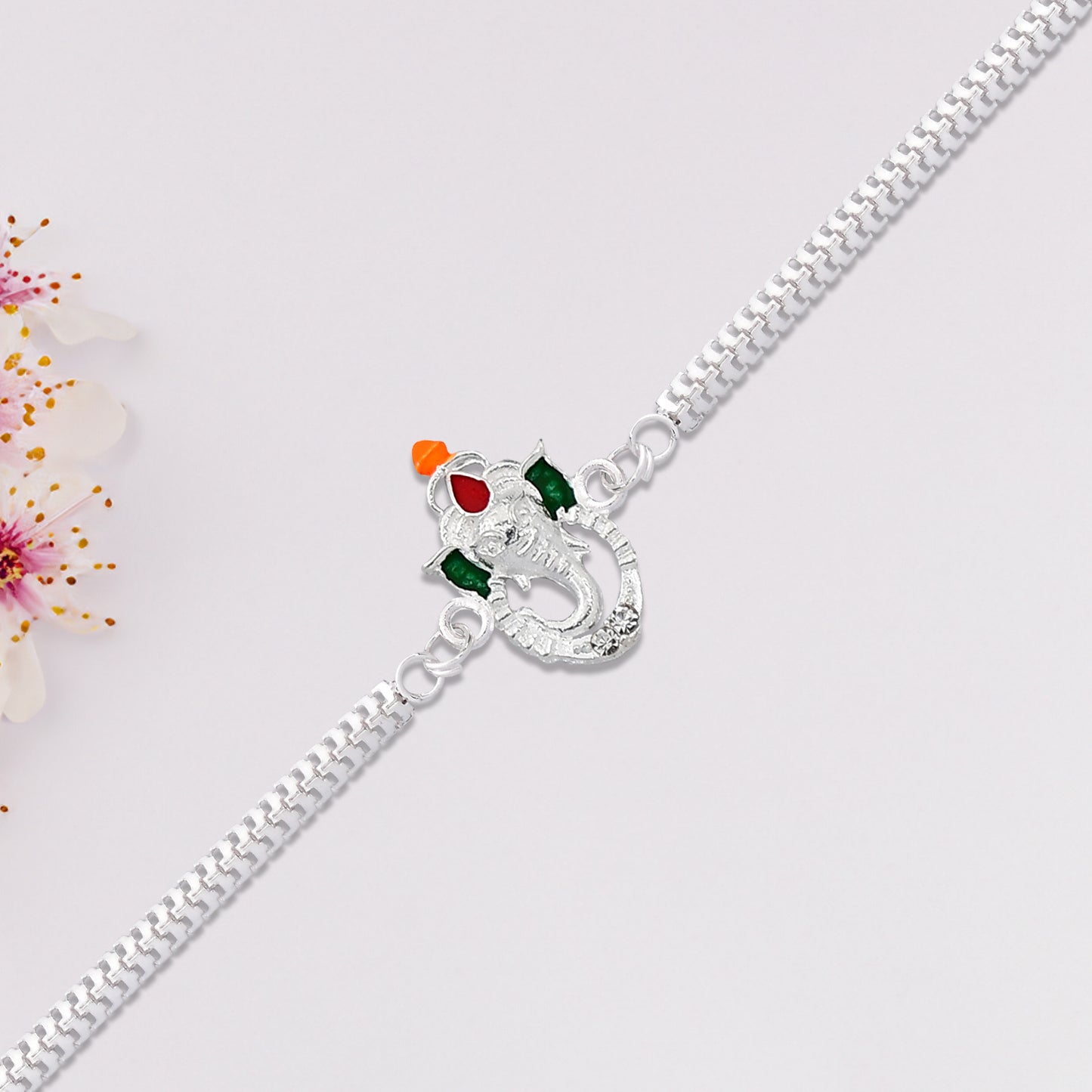 Stylish Ganesha Rakhi With Enamel Highlights And Silver Metal Chain